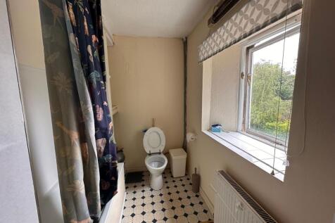 A bright bathroom featuring a large window with...