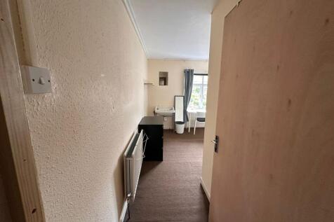 A narrow hallway leading to a bright window wit...