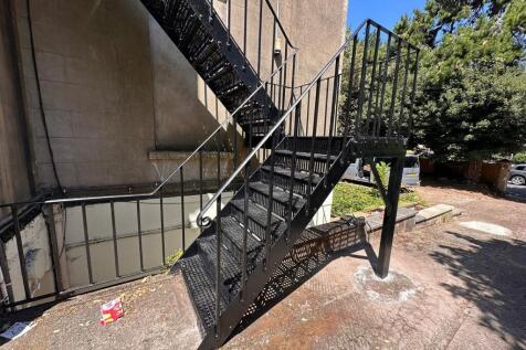 Outdoor metal staircase attached to a building,...