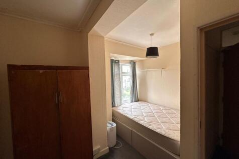 A cozy single bedroom with a comfortable bed po...