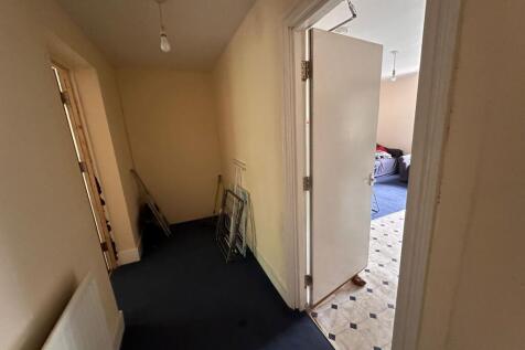 A simple hallway with soft cream walls and dark...