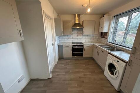 Bright and clean kitchen with modern cabinetry,...