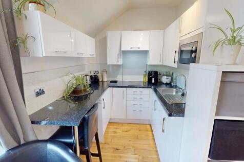 Bright and modern kitchen featuring sleek white...
