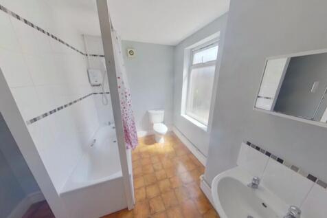 A spacious and bright bathroom featuring a bath...