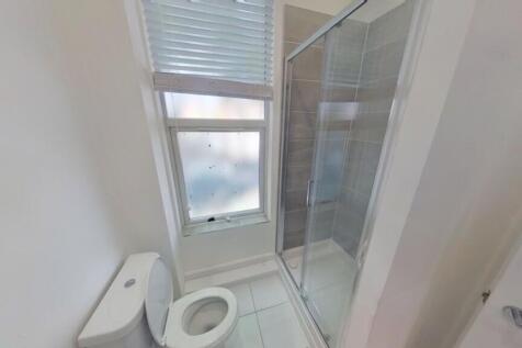 A modern and clean bathroom featuring a shower,...