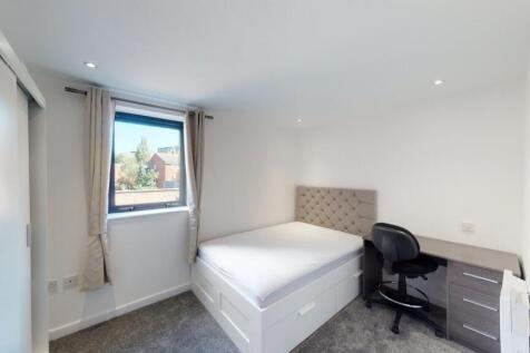 Bright and clean master bedroom featuring a com...