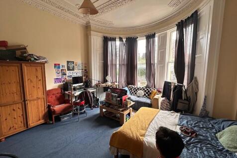 Spacious master bedroom with a charming bay win...