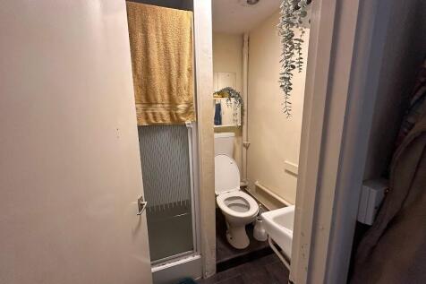 Compact and functional bathroom featuring a sho...