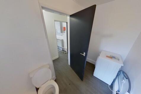 A clean and simple single toilet room featuring...