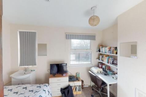 A bright and cozy single bedroom featuring a co...