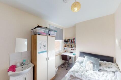 A cozy single bedroom featuring a neatly made s...