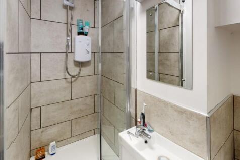 A modern bathroom suite featuring a walk-in sho...