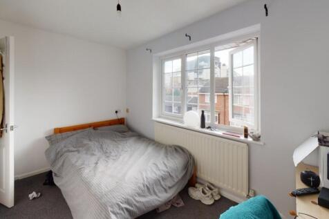 A cozy double bedroom featuring a large window ...