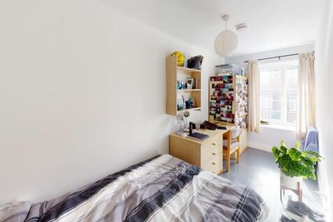 A bright and tidy single bedroom featuring a co...