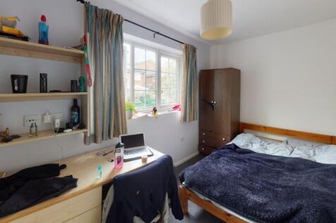 A cozy single bedroom with a comfortable bed, a...