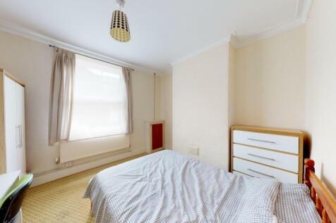 A bright double bedroom featuring a neatly made...