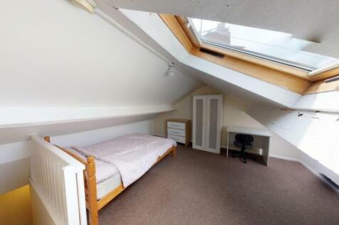 Bright and cozy attic bedroom featuring a skyli...