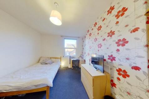 Cozy single bedroom featuring a bright window, ...