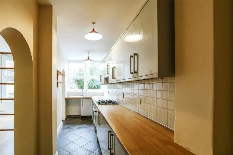 A bright and clean galley kitchen featuring lig...