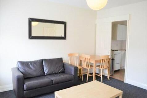 A bright and tidy living room featuring a comfo...