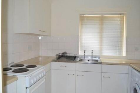 Bright and functional kitchen featuring white c...