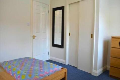 A neat and tidy single bedroom featuring a bed ...