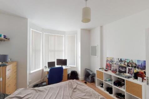 Bright and airy master bedroom featuring a larg...