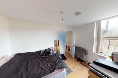 A bright double bedroom featuring a large windo...