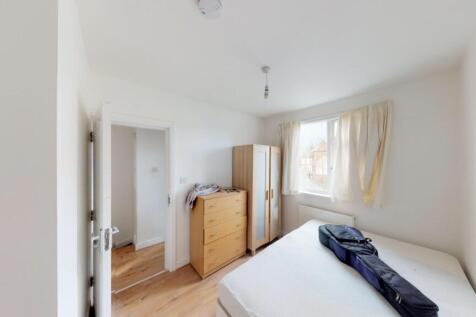 A bright double bedroom featuring a large windo...
