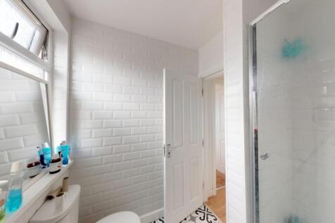 A bright and clean bathroom featuring a glass-e...