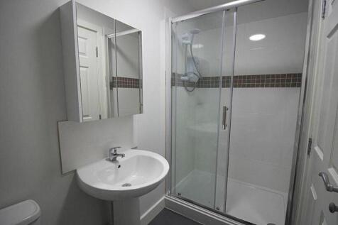 A modern bathroom suite featuring a spacious sh...