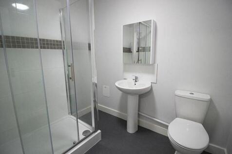 This modern bathroom features a spacious shower...