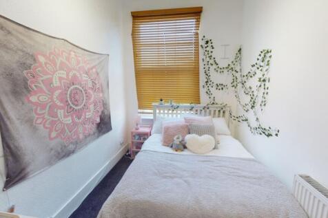 A cozy, well-kept single bedroom featuring a co...