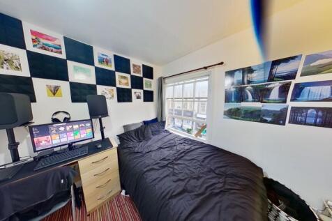 A cozy, well-lit bedroom featuring a comfortabl...