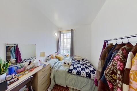 Bright and cozy bedroom featuring a neatly made...