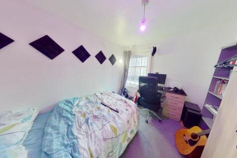 A cozy single bedroom featuring a comfortable b...