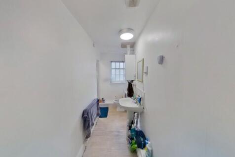 Bright and clean hallway with white walls and t...
