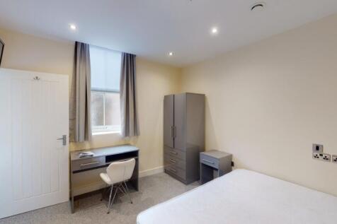 A neat and well-lit bedroom featuring a clean s...