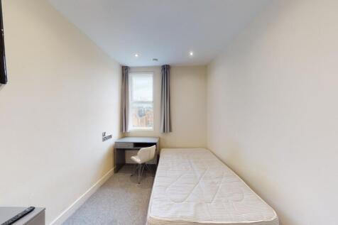 A neat and simple single bedroom featuring a co...