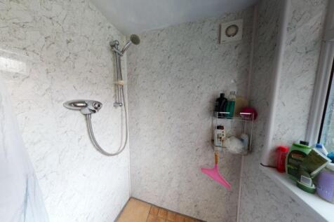 Bright and tidy bathroom featuring a walk-in sh...