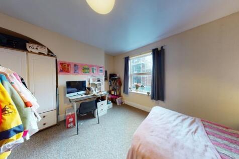 A cozy single bedroom with a comfortable bed by...