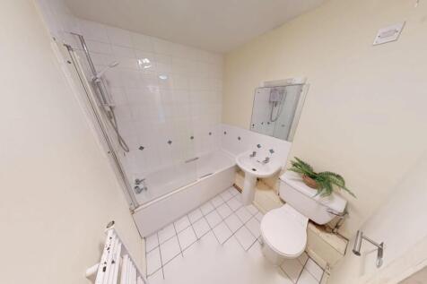 A clean and bright bathroom featuring a white t...