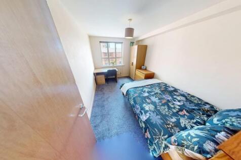 A cozy single bedroom featuring a neatly made b...