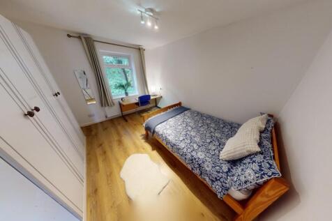 Bright and tidy single bedroom featuring wooden...