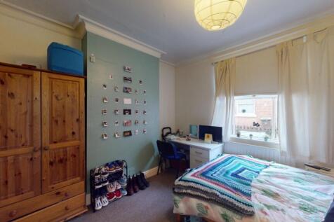 Cozy and well-lit single bedroom featuring a co...