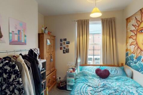A cozy bedroom with a vibrant sun-themed mural ...