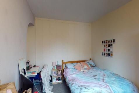 A cozy single bedroom with a comfortable bed, d...
