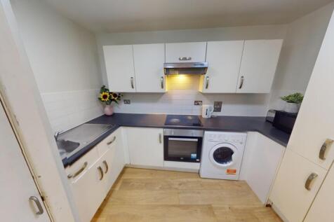 A modern and tidy kitchen featuring white cabin...