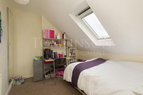 A cozy single bedroom featuring a comfortable b...