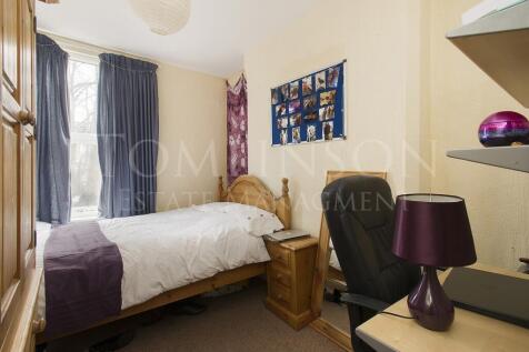 A cozy single bedroom featuring a comfortable b...